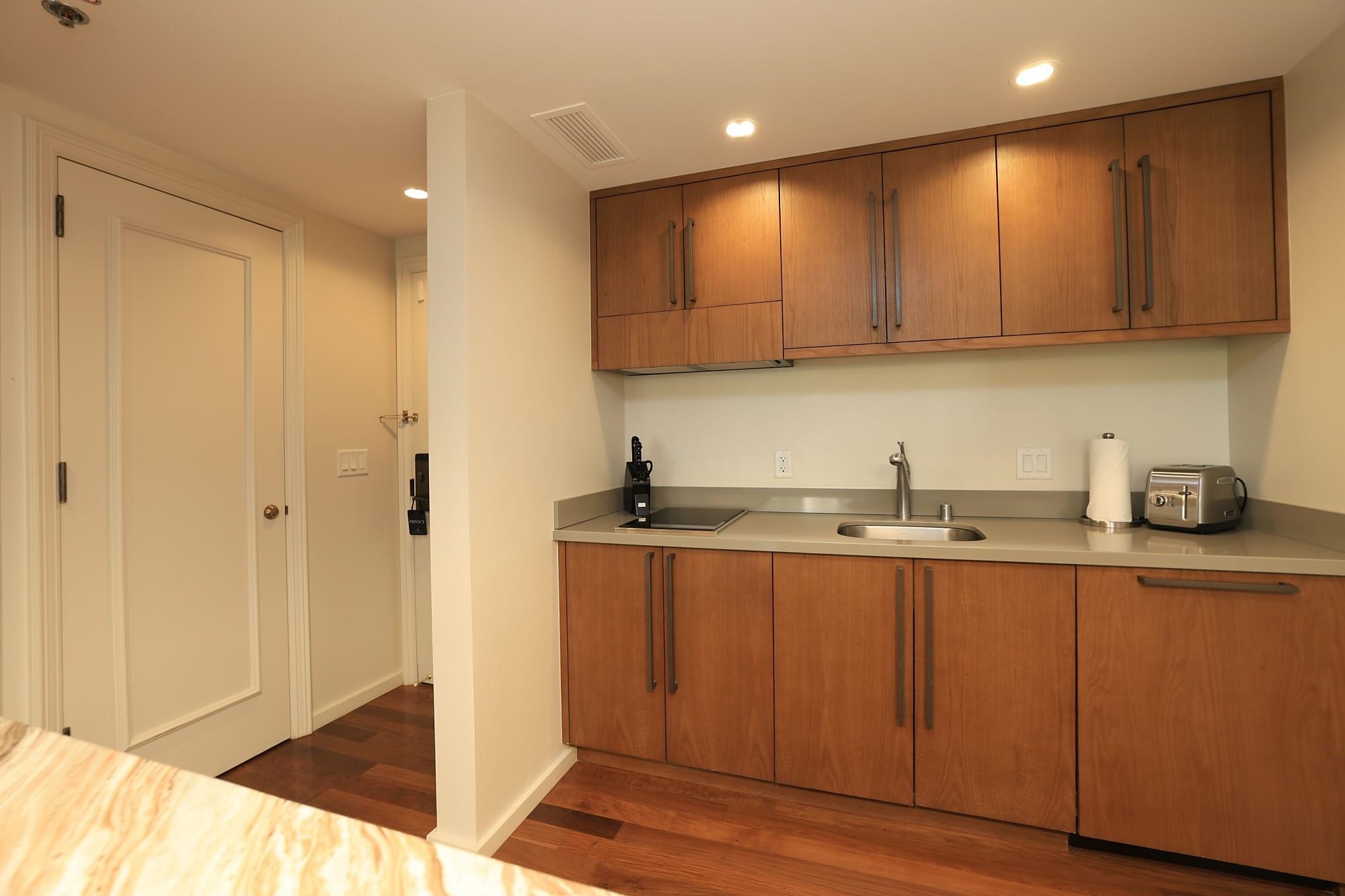 1 Ritz Carlton Drive, Unit 1502 Lahaina, HI 96761 - Photo 8 of 47 a kitchen with stainless steel appliances granite countertop wooden cabinets a sink and dishwasher