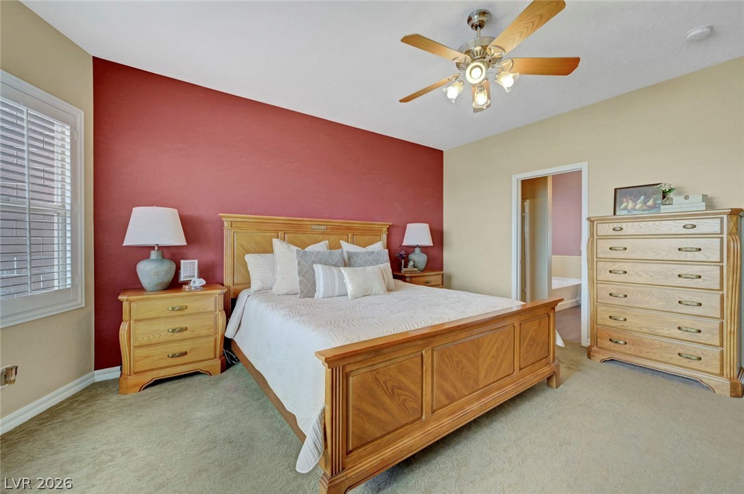 2700 Rue Montpellier Avenue Henderson, NV 89044 - Photo 22 of 39 Bedroom featuring a ceiling fan, ensuite bath, and light carpet