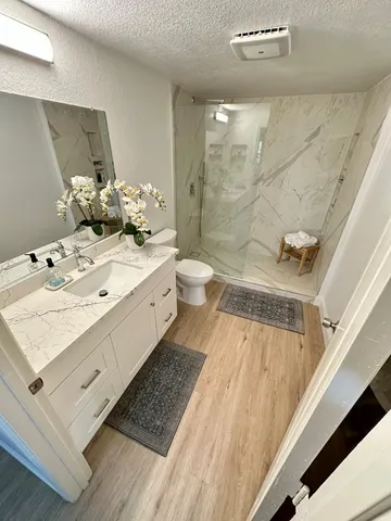 a bathroom with a sink a toilet and shower