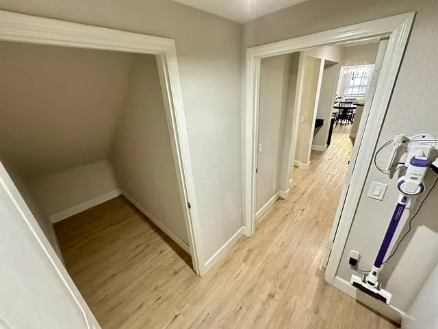 a view of a hallway with wooden floor and staircase