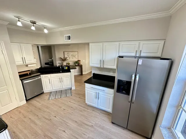 a kitchen with stainless steel appliances a refrigerator a sink a stove a microwave and island