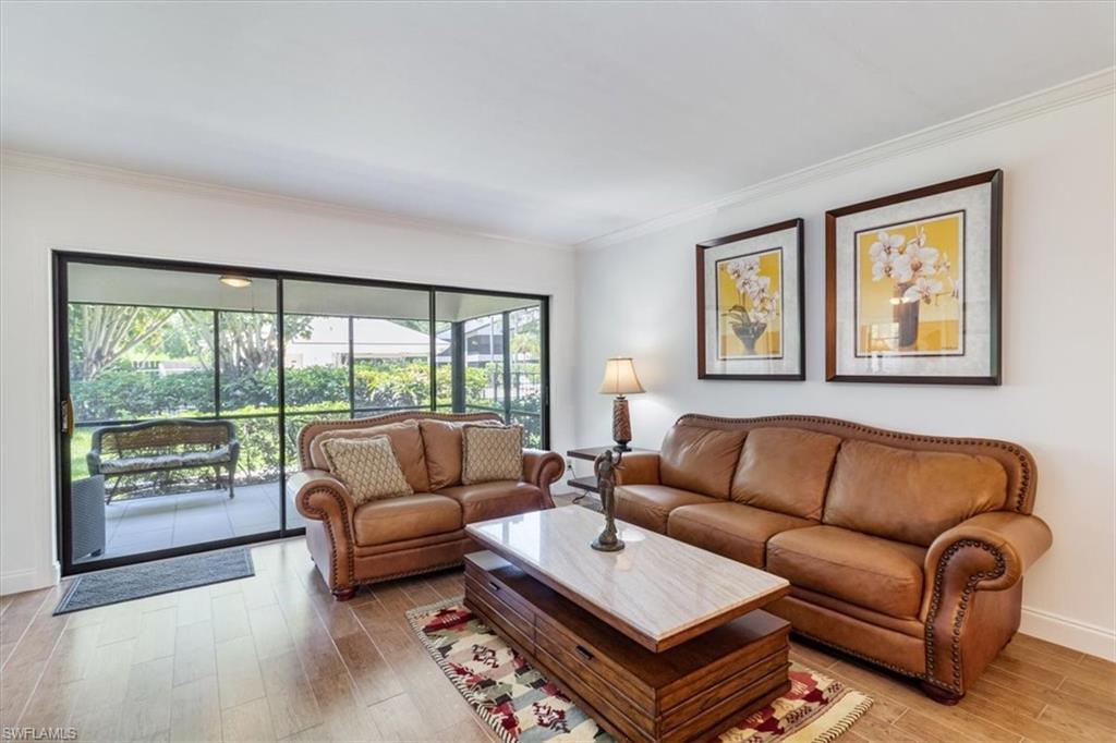 1816 Kings Lake Boulevard, Unit 101 Naples, FL 34112 - Photo 1 of 20 Living room with tile wood-like flooring and ornamental molding