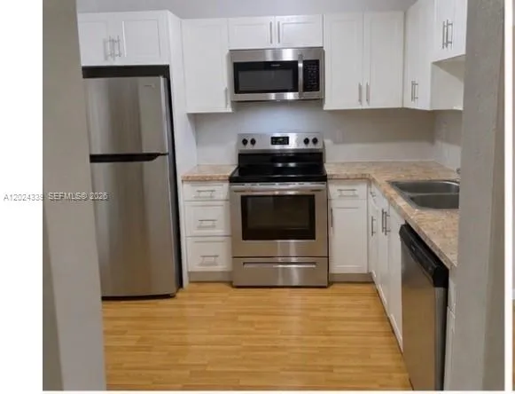 a kitchen with stainless steel appliances granite countertop a stove a refrigerator and a microwave