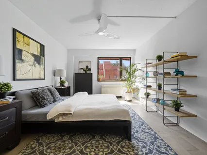 a bedroom with a bed a table and painting on the wall