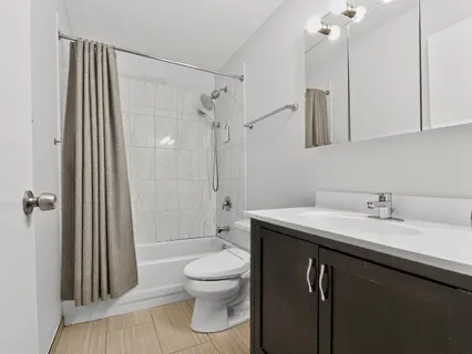 a bathroom with a granite countertop sink toilet and shower