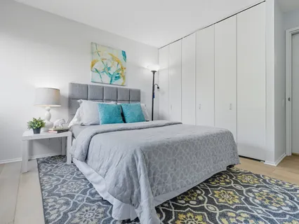 a bedroom with a bed and a painting on the wall