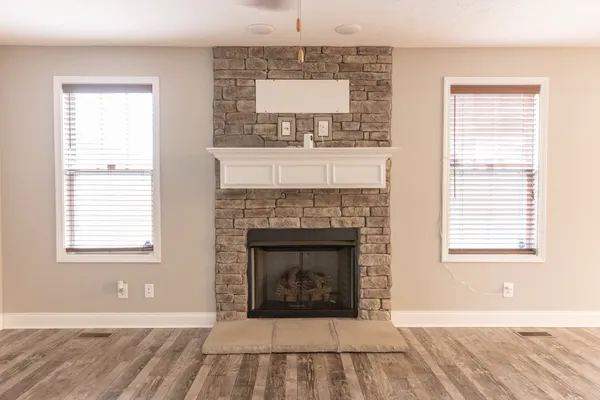a living room with a fireplace and windows