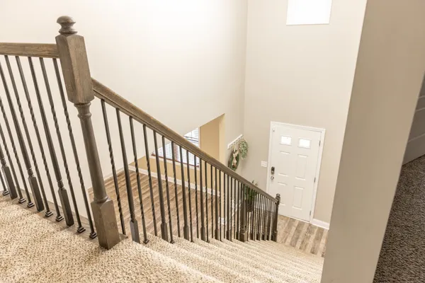 a view of staircase with railing and white walls