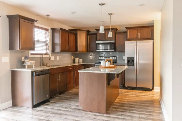 a kitchen with a refrigerator a sink and cabinets