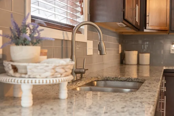 a room with a granite countertop sink and a mirror