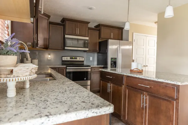 a kitchen with stainless steel appliances granite countertop a sink stove and refrigerator