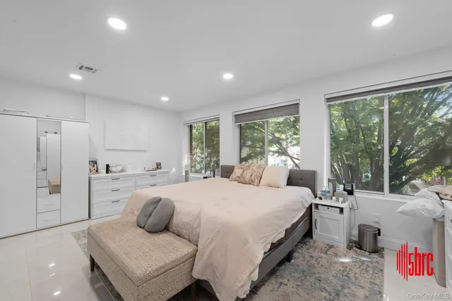 a large bedroom with a large bed and windows