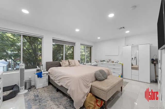 a bedroom with a bed and a large window