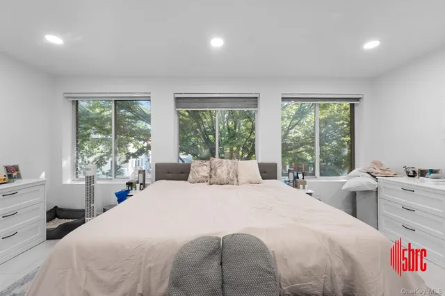 a bedroom with a bed and a large window