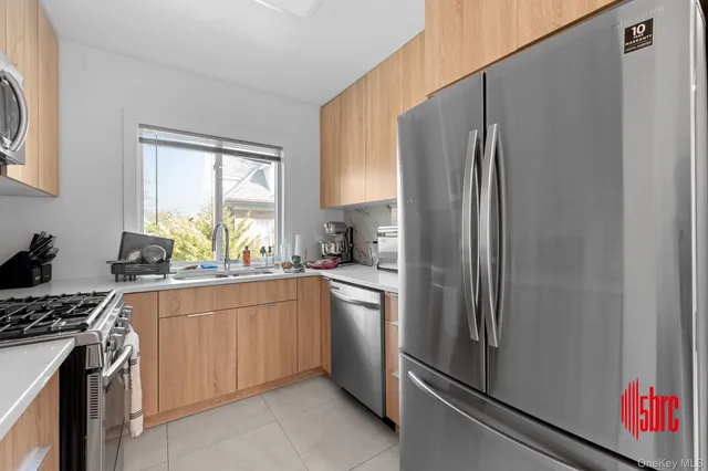 a kitchen with stainless steel appliances a refrigerator sink and stove