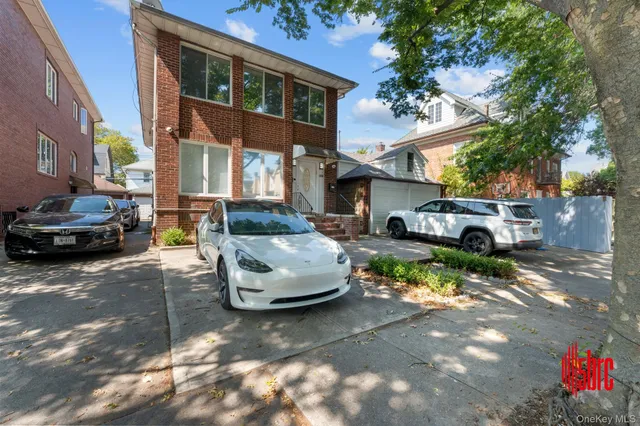 a front view of a house with a garden and parking