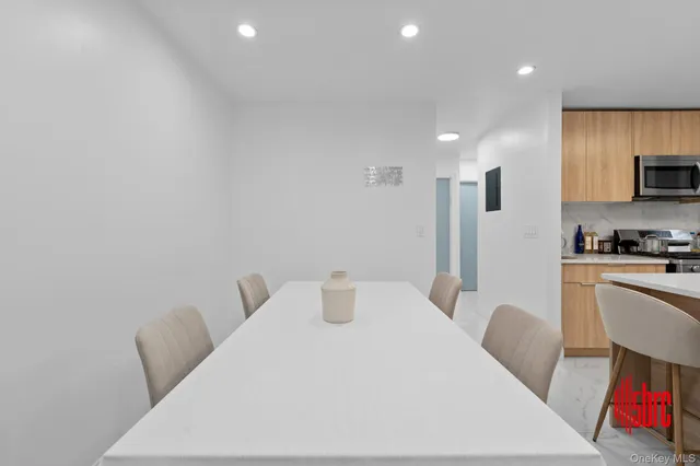 a kitchen with a sink dishwasher a stove a dining table and chairs with wooden floor