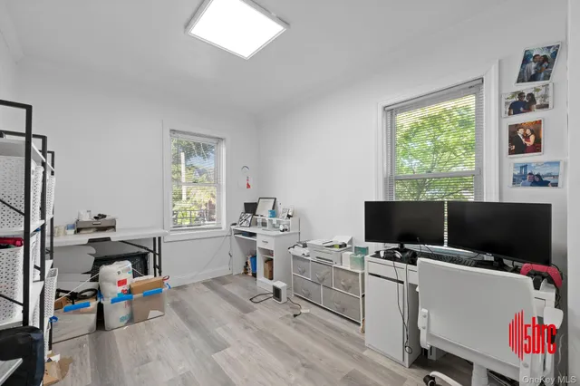 a view of a workspace with furniture and a window