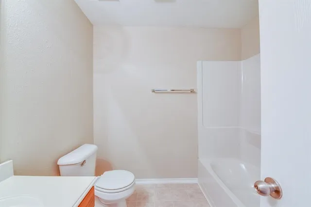 a white toilet sitting next to a bath tub