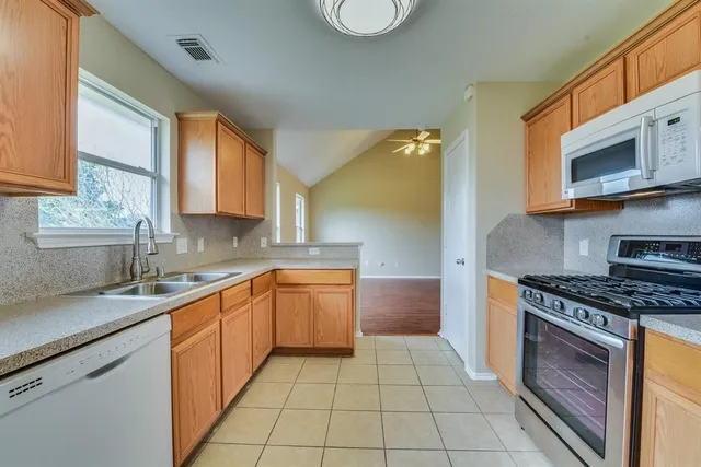 a kitchen with stainless steel appliances granite countertop a sink and a stove