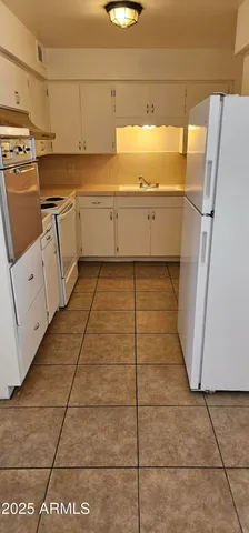 a view of a kitchen with white cabinets