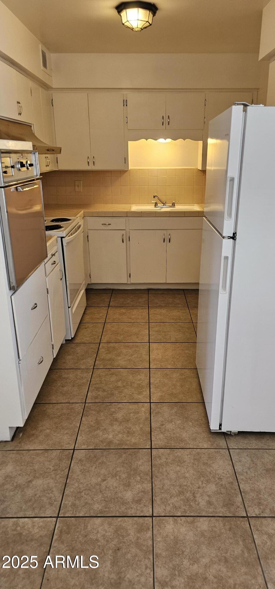 62 South Allen, Unit A Mesa, AZ 85204 - Photo 6 of 15 a view of a kitchen with white cabinets