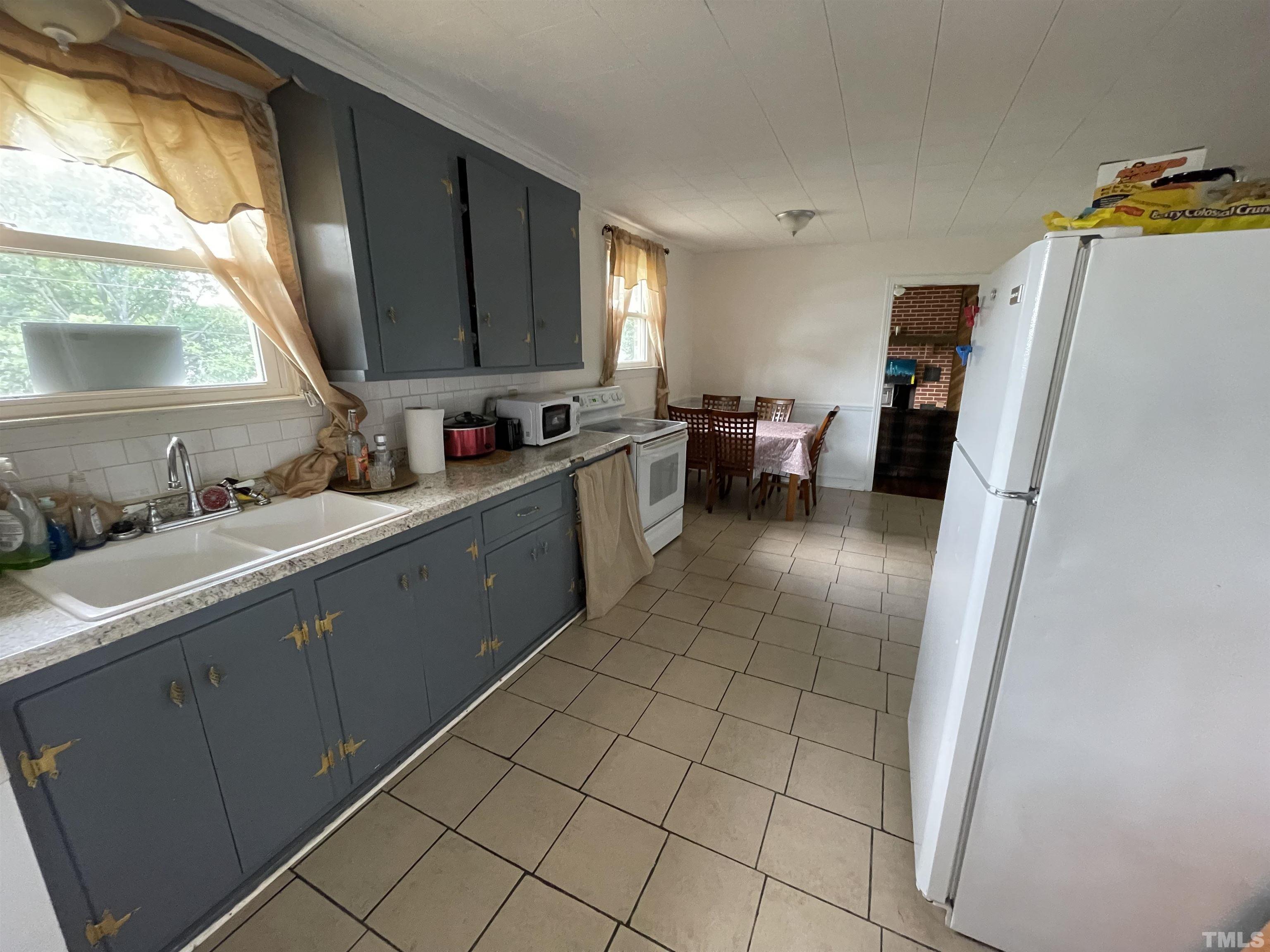 1416 Jackson Street Roxboro, NC 27573 - Photo 5 of 15 a kitchen with a sink a refrigerator and a stove