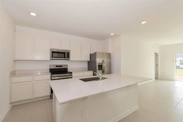 a kitchen with stainless steel appliances a refrigerator stove microwave and sink