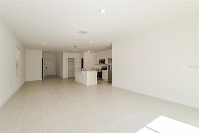 a view of a kitchen with a refrigerator and a microwave