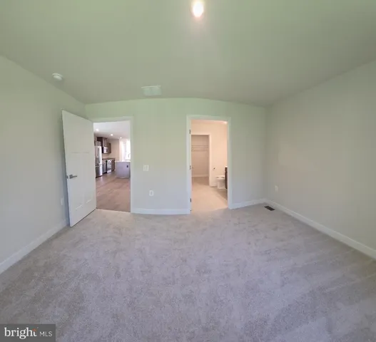an empty room with windows and bathroom view