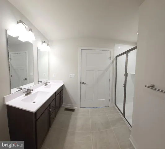 a bathroom with a double vanity sink and mirror