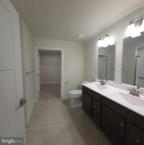 a spacious bathroom with a double vanity sink mirror and toilet