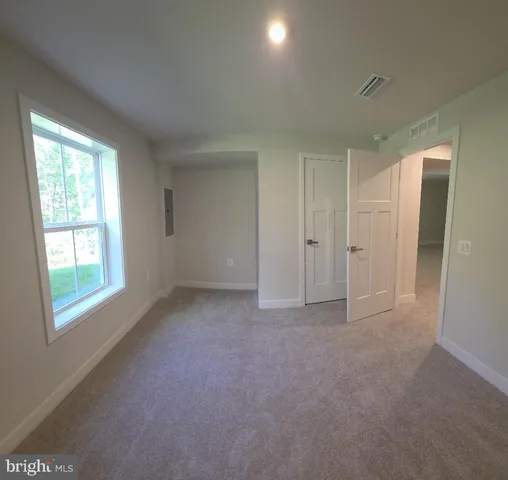 an empty room with windows and closet