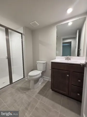 a spacious bathroom with a toilet a sink a mirror and a faucet