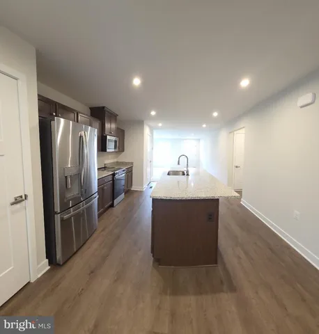 a view of kitchen with refrigerator microwave and wooden floor