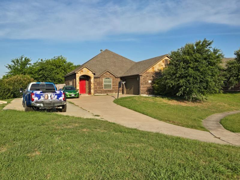 104 Anthony Lane Red Oak, TX 75154 - Photo 4 of 6 Brick and stone exterior featuring a prominent red entry door and an attached garage