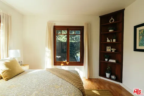 a bedroom with a bed and a painting on the wall