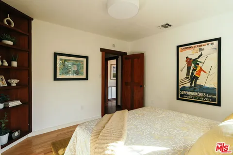 a bedroom with a bed and a potted plant