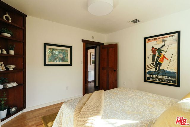 a bedroom with a bed and a potted plant
