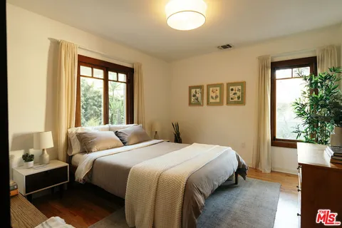 a bedroom with a bed and wooden floor