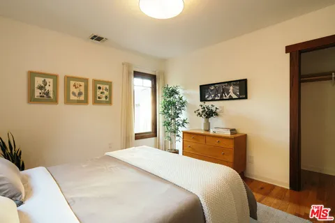 a bedroom with a bed and a plant