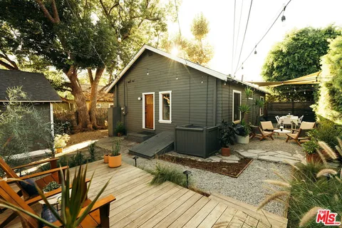 a roof deck with table and chairs and potted plants
