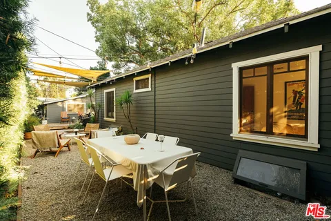 a view of a house with backyard and sitting area