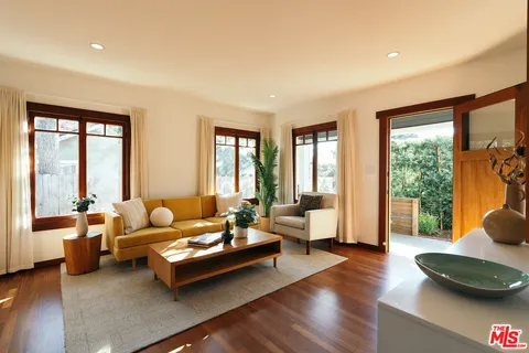 a living room with furniture and floor to ceiling windows