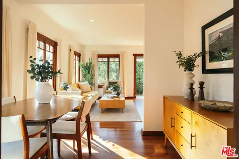 a kitchen with stainless steel appliances granite countertop a refrigerator a sink dishwasher a stove and white countertops with wooden floor