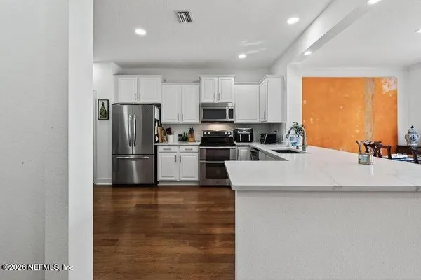 a kitchen with kitchen island a counter top space a sink and stainless steel appliances
