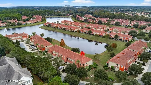 an aerial view of lake and residential houses with outdoor space