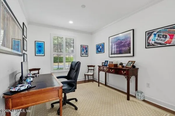 a view of a workspace with furniture and a window