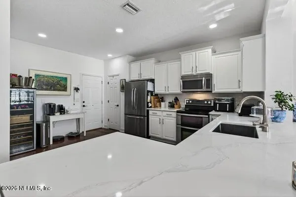 a kitchen with granite countertop a refrigerator stove and sink