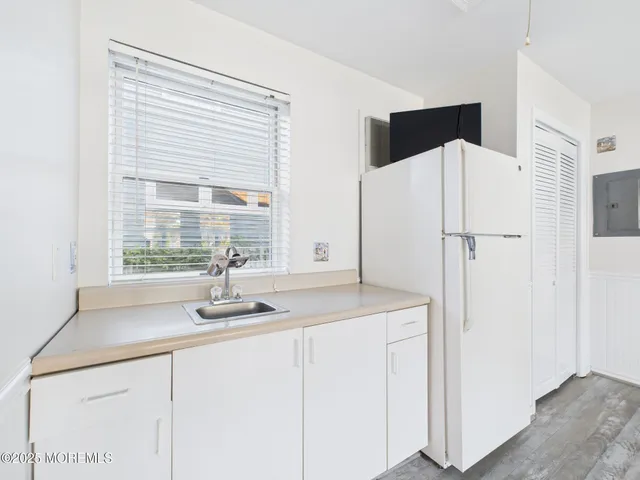 a white cabinet with two windows and a sink